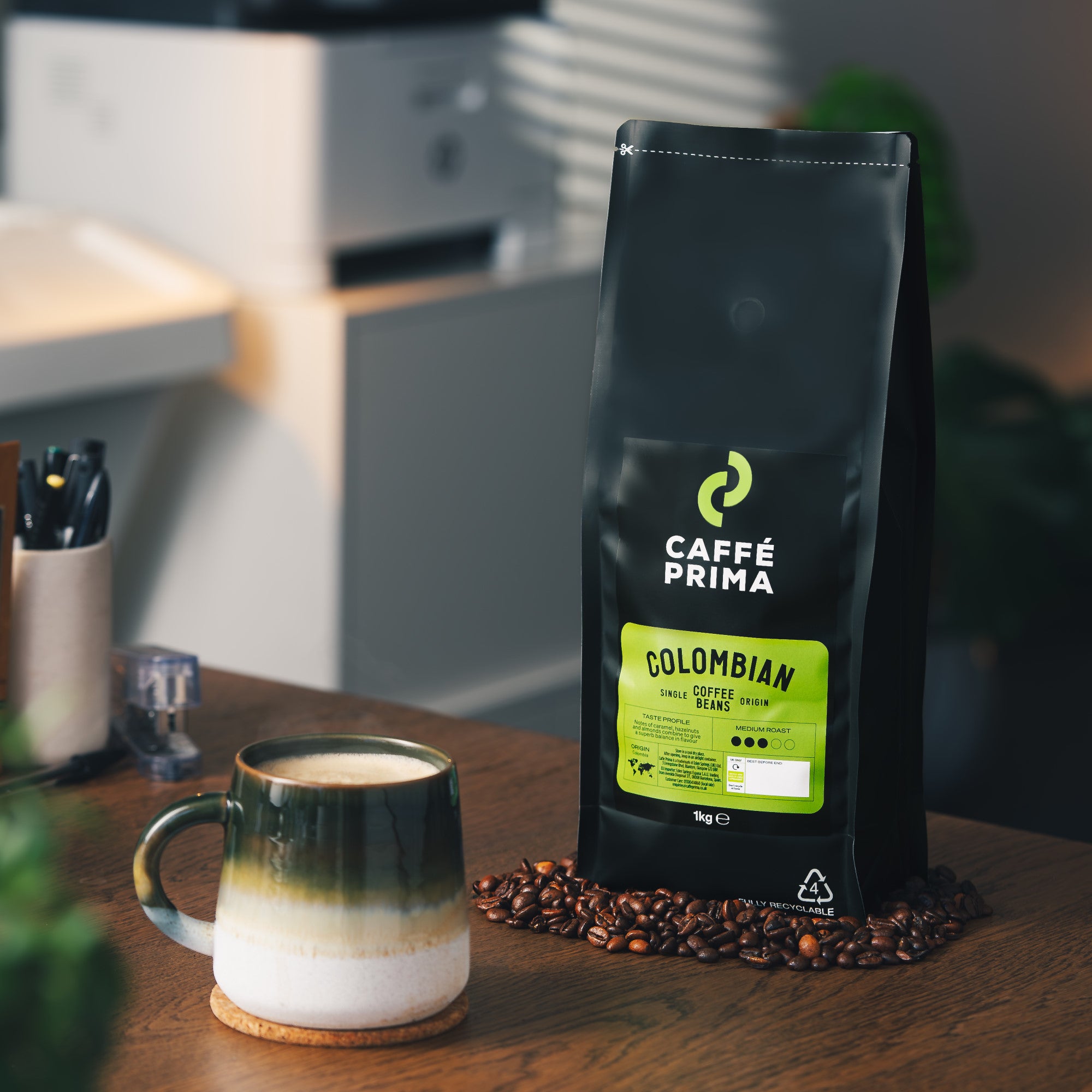 A packshot of Caffe Prima Colombian Coffee Beans on a green background