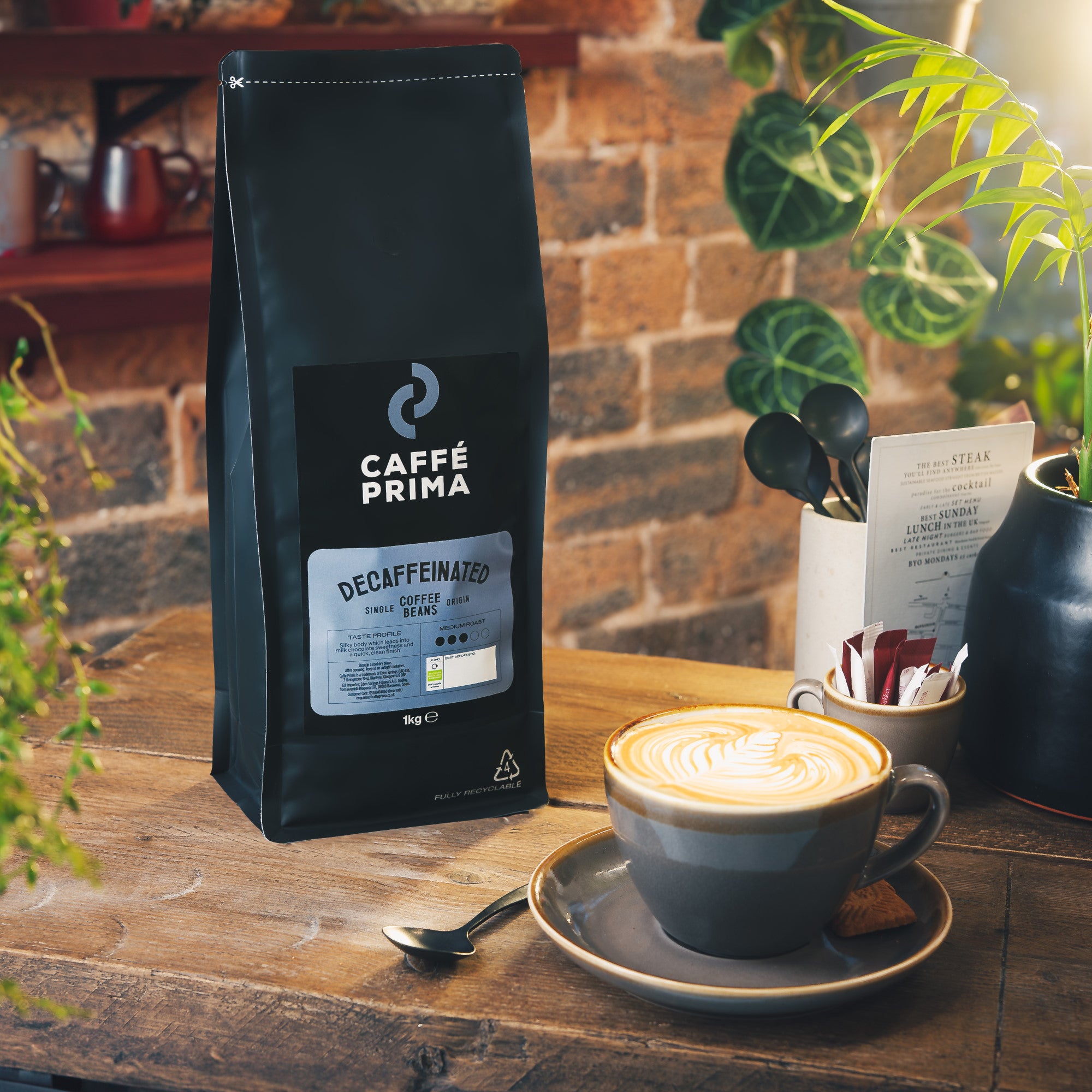 A packshot of Caffe Prima Decaffeinated Coffee Beans on a blue background