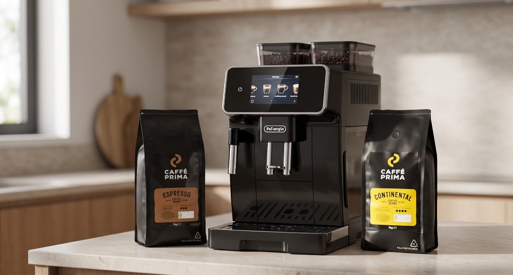 De'Longhi Rivelia coffee machine on a kitchen counter next to two Caffé Prima coffee bean bags, Espresso Blend and Continental Blend