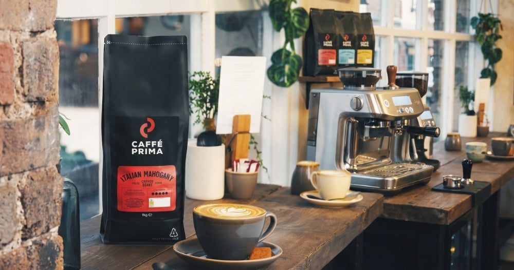 A pack of Caffe Prima Italian coffee beans next to the Sage Bambino Coffee Machine