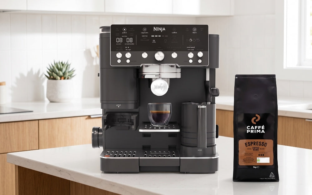 The Ninja Luxe Café coffee machine and a bag of Caffe Prima Espresso coffee beans on a kitchen table