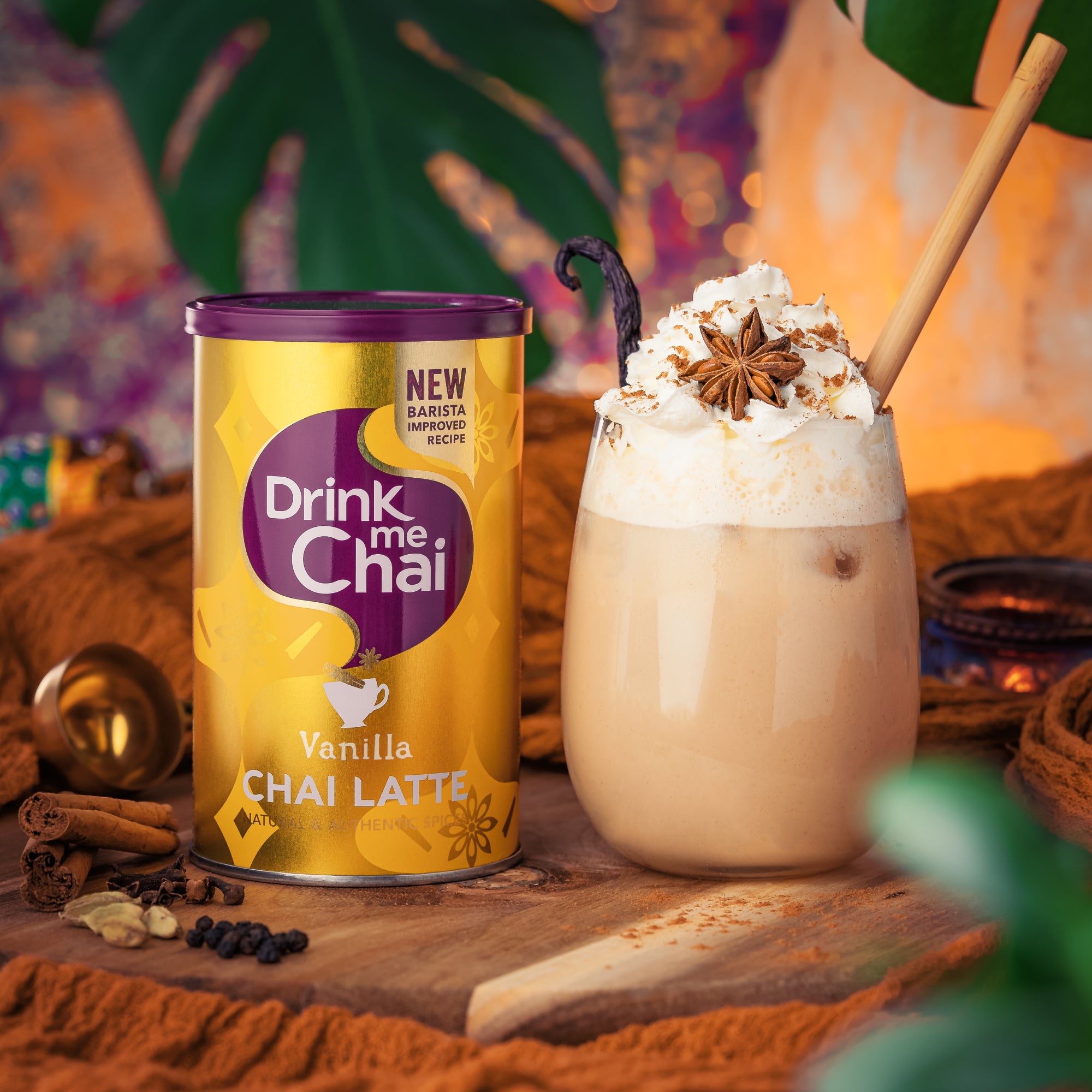 A lifestyle shot of Drink Me Chai Vanilla Chai Latte 250g served as an iced chai latte in a glass with a straw